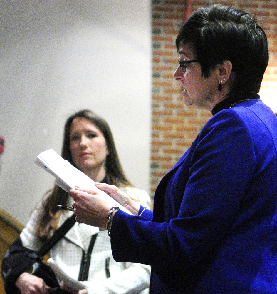 Rep. Gay Grant, D-Gardiner, reads from Gov. Paul LePage’s State of the State letter while asking him a question Tueday evening during a town hall-style meeting at Hall-Dale High School in Farmingdale.