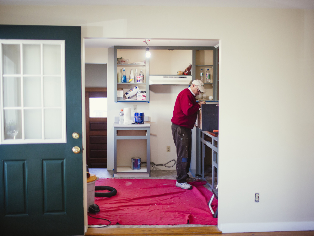 Landlord Carleton Winslow repairs cabinets in a single-family home he’s renovating in Portland. Small residential renovation projects make up an estimated 60 percent of the permit applications that come into Portland City Hall.