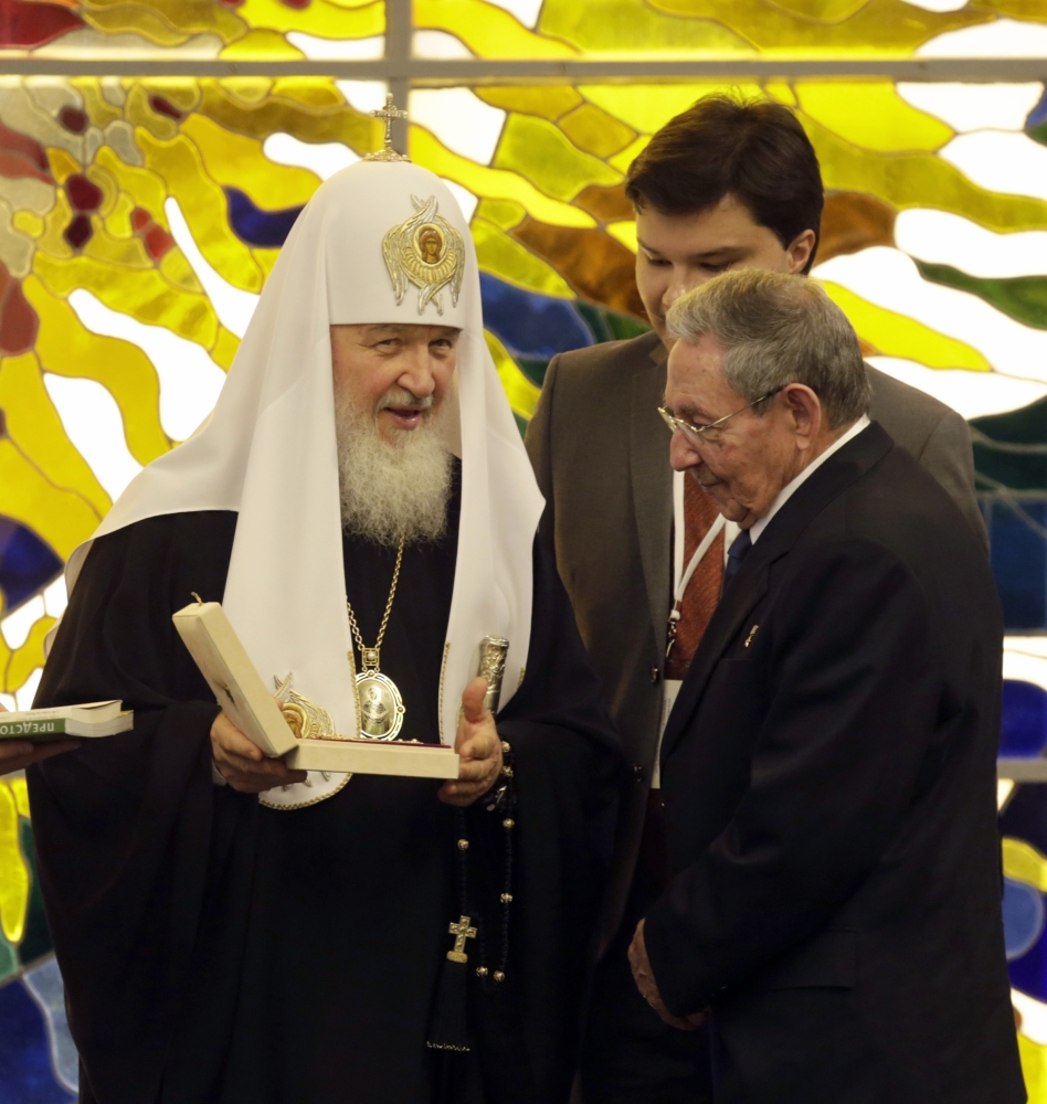 Patriarch Kirill exchanges gifts with Cuban President Raul Castro, right, at Revolution Palace Friday. Kirill is visiting leaders and Russian Orthodox communities in Latin America.