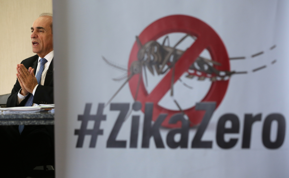 Brazil’s Health Minister Marcelo Castro speaks during an interview at the Health Ministry headquarters, in Brasilia, Brazil, Friday, Feb. 12, 2016. Castro made his remarks with a poster with an image of an Aedes aegypti mosquito and a text in Portuguese that reads "Zero Zika." (AP Photo/Eraldo Peres)