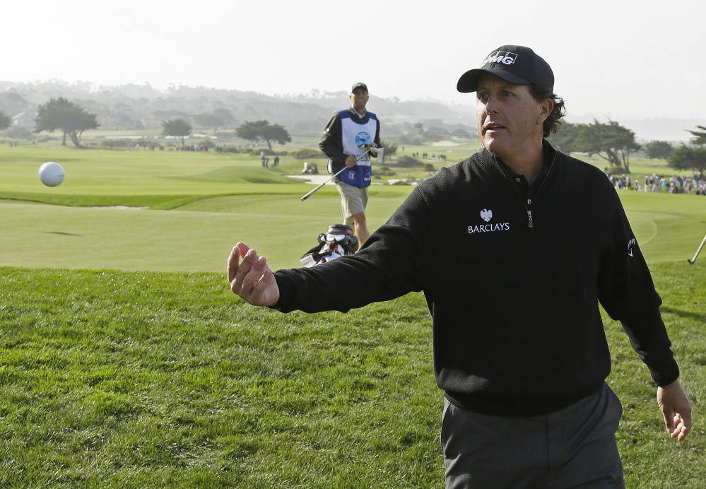Phil Mickelson tosses his ball to the gallery after putting on the sixth green of the Monterey Peninsula Country Club Shore Course during the second round of the Pebble Beach Pro-Am on Friday in Pebble Beach, California.