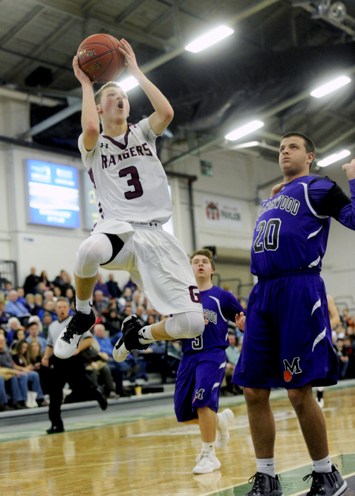 Derek Davis/Staff Photographer
Jordan Bagshaw of Greely puts up a shot as Jack Spear of Marshwood avoids causing a foul during the second quarter.