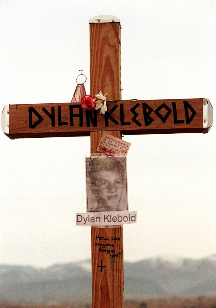 This April 28, 1999 file photo shows a cross bearing the name and likeness of Dylan Klebold and a message “How can anyone forgive you?” on a hill in Littleton, Colo., near Columbine High School where someone erected crosses to honor the dead.