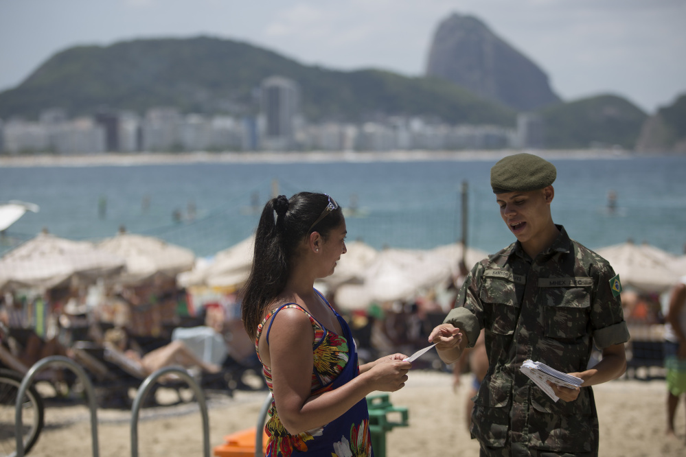 A soldier explains how to combat the Aedes aegypti mosquito that spreads the Zika virus, on Copacabana beach in Rio de Janeiro, Brazil, on Saturday. More than 200,000 troops are part of the nationwide effort to eliminate the mosquitoes.