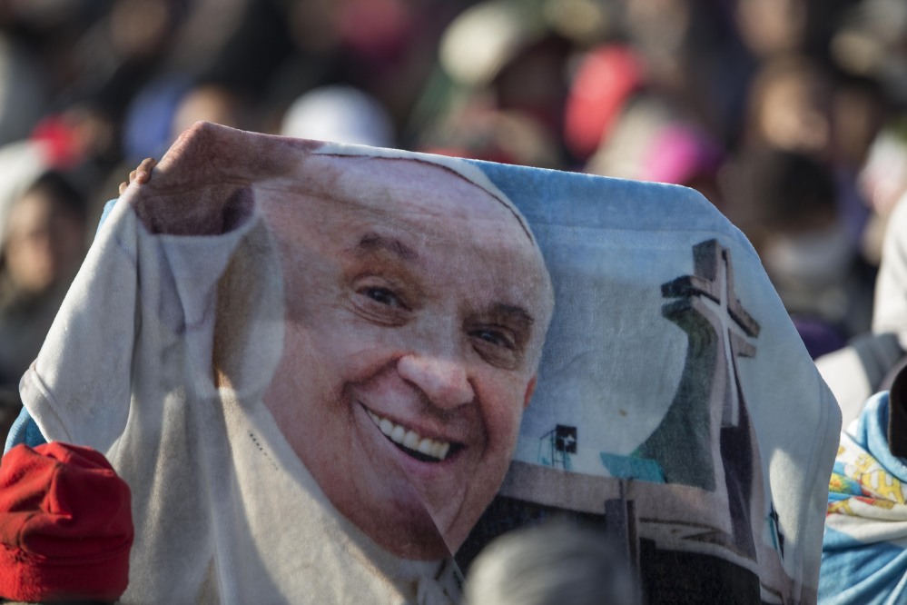 A person holds a blanket with the image of Pope Francis during the wait for his arrival in Ecatepec, Mexico on Sunday.