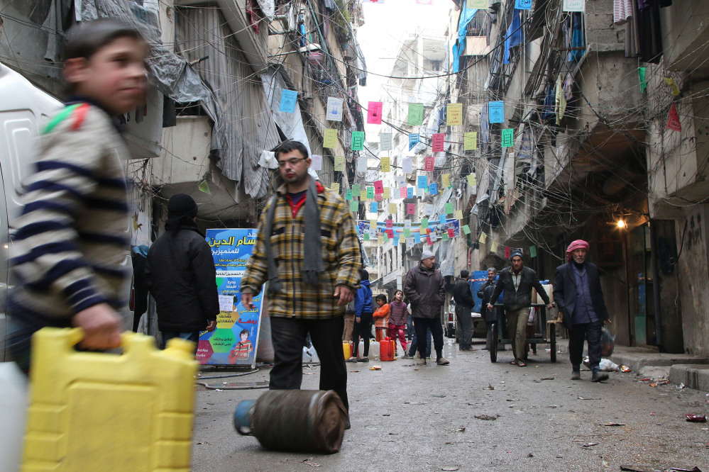 Civilians carry supplies Thursday in Aleppo, Syria.