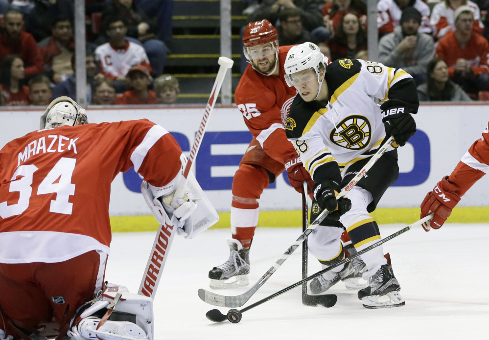 Boston Bruins left wing David Pastrnak (88) shoots on Detroit Red Wings goalie Petr Mrazek (34) during the first period Sunday in Detroit. The Associated Press
