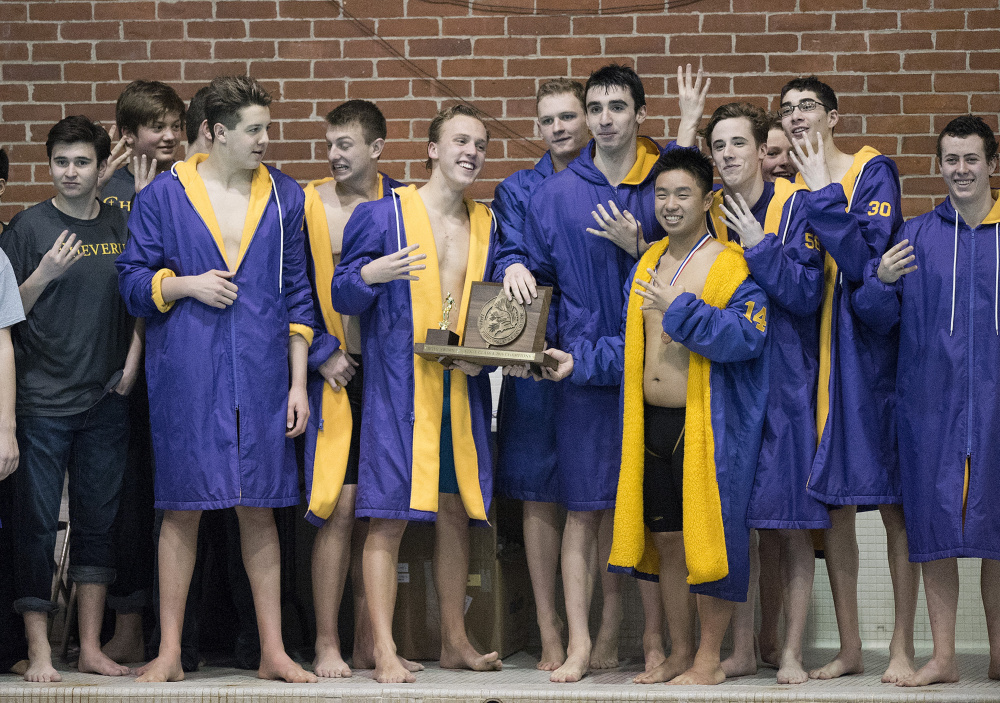 Members of the Cheverus boys’ swim team celebrate with the championship trophy Monday after winning the Class A state title – for the fourth year in a row – at the University of Maine in Orono. Kevin Bennett photo