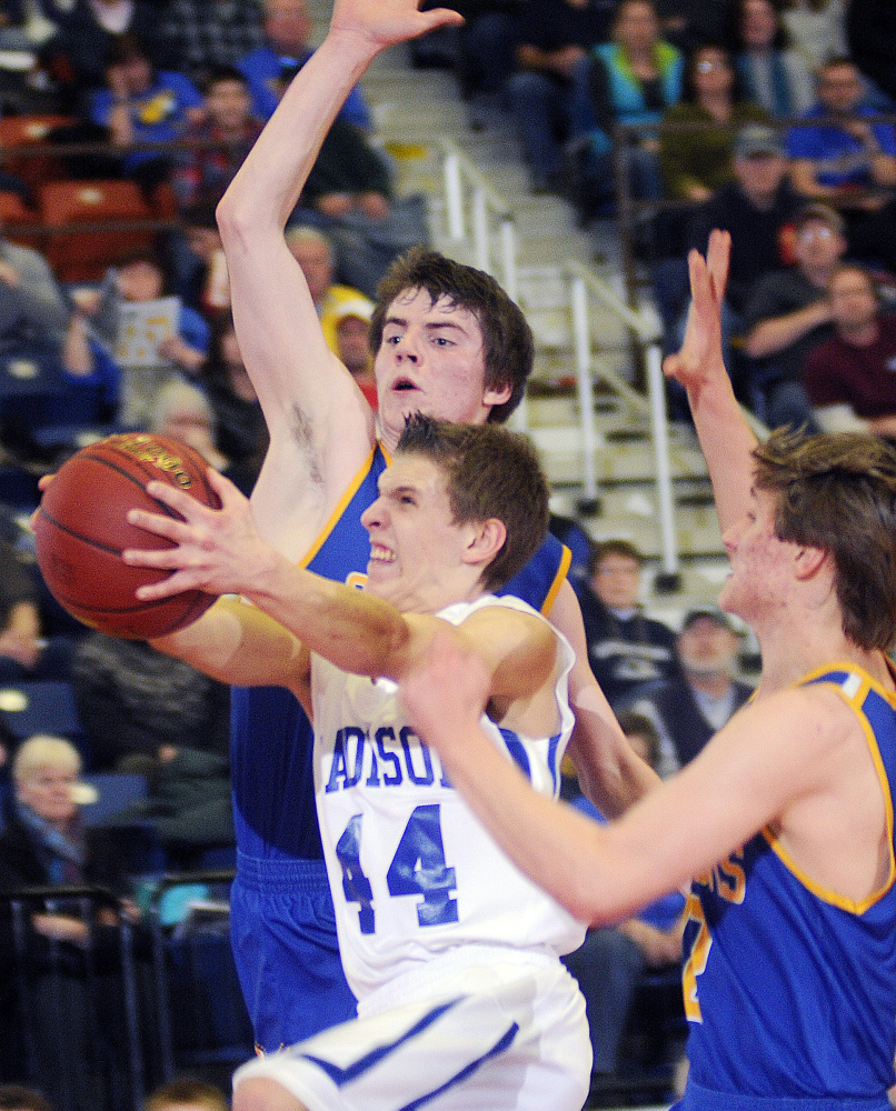 Madison senior Christopher Beaman, middle, moves by Boothbay’s Nick Gorey, left, and Kyle Ames during a Class C South quarterfinal Monday afternoon at the Augusta Civic Center.
