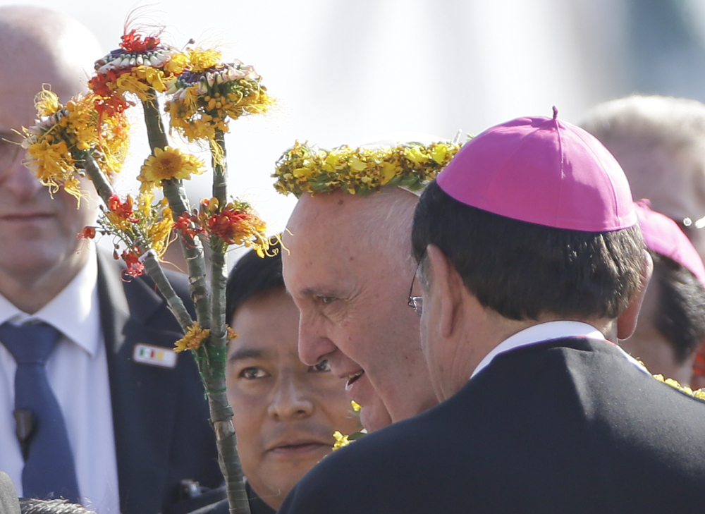 Pope Francis wears a crown of flowers, given to him by indigenous Mexicans, as he arrives at the airport in Tuxtla Gutierrez, Mexico, on Monday. Francis celebrated Mexico’s Indians with a visit to Chiapas state, a center of indigenous culture, where he presided over a Mass.