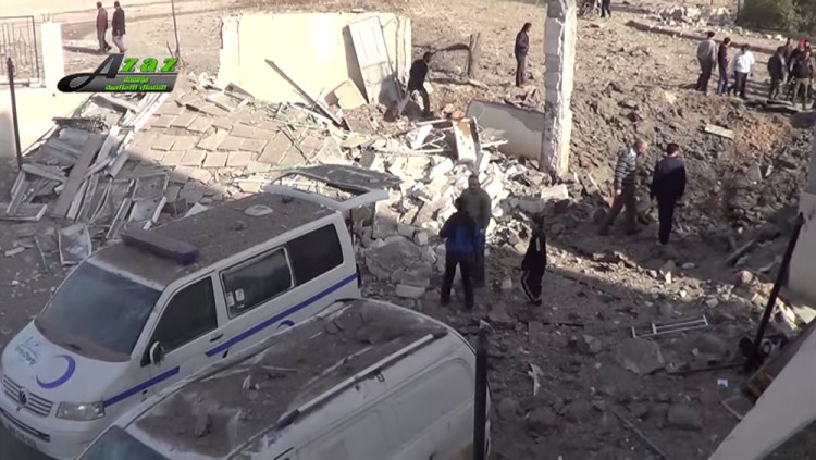 This image taken from video provided by the Syrian activist-based media group Azaz Media Center, which has-been verified and is consistent with other AP reporting, shows people gathered around destroyed vehicles in Azaz, Syria Syria, Monday.
