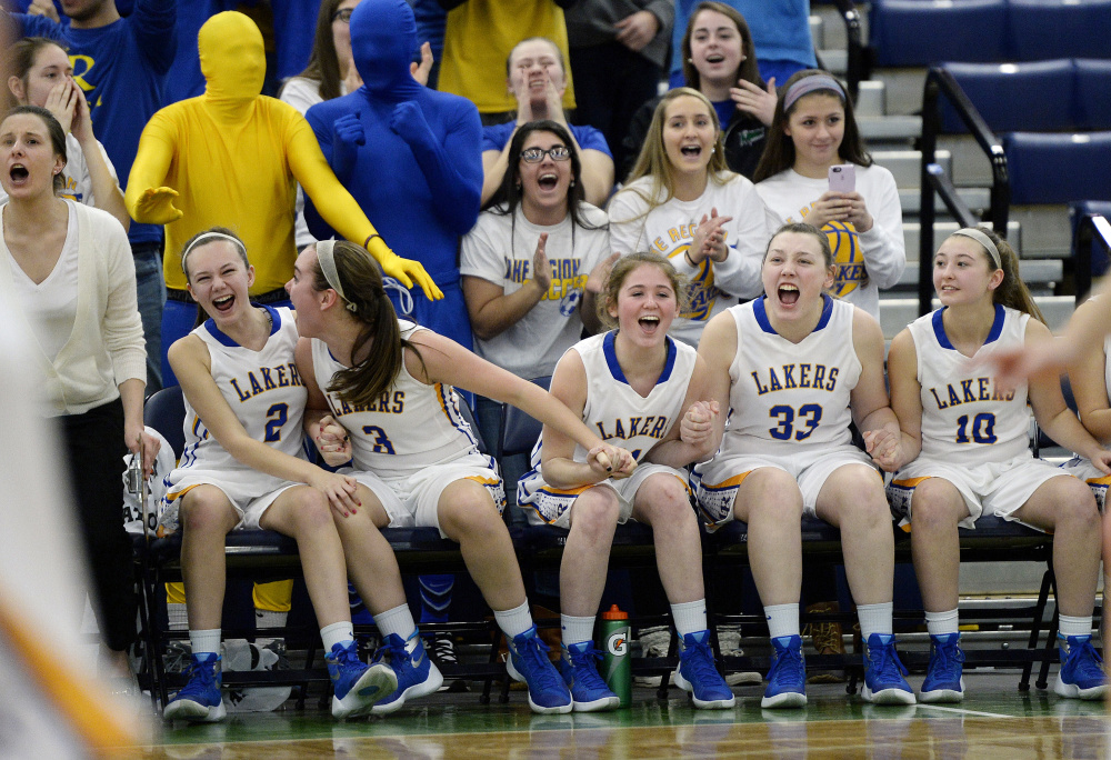 The Lake Region bench reacts after a teammate makes a free throw to take the lead in the closing seconds of their girls’ basketball quarterfinal against Yarmouth on Tuesday at the Portland Expo. (Photo by Shawn Patrick Ouellette/Staff Photographer)