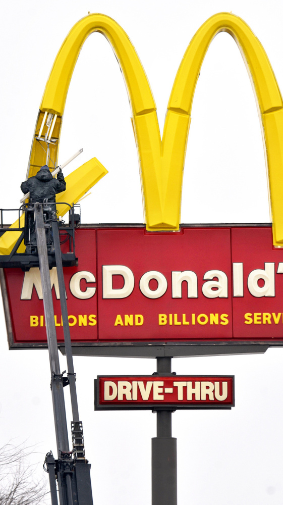 An installer changes bulbs in a McDonald’s restaurant sign in Marion, Ind., on Monday.