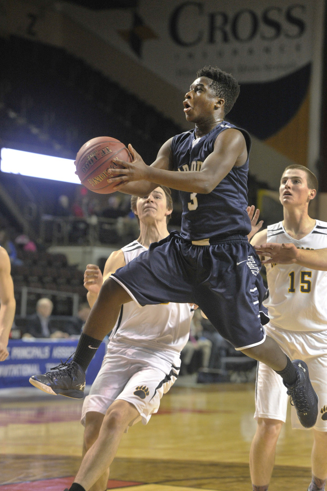 Yarmouth’s Musseit M’Bareck goes in for a layup in front of Maranacook’s Levi Emery, left, and Jason Brooks during their Class A South boys’ basketball semifinal Thursday night at Cross Insurance Arena. Yarmouth won, 69-51.