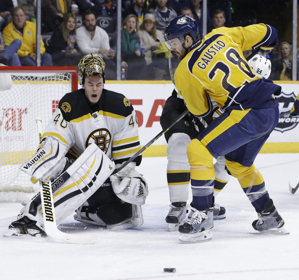 Bruins goalie Tuukka Rask loses his mask as Nashville’s Paul Gaustad vies for the puck during in second period Thursday at Nashville, Tennessee.