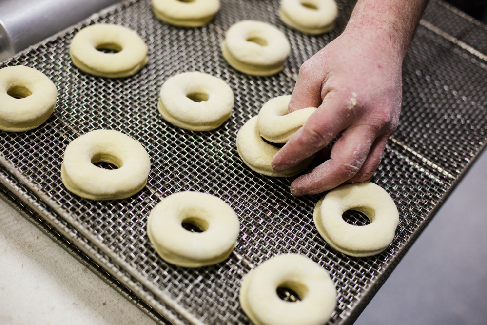 Steven Whitman arranges plain raised doughnuts that are ready to be fried and glazed on a rack at Frosty’s baking facility in Brunswick. Krispy Kreme Doughnuts plans to open three locations in Maine in the next few years, but Maine doughnut shop owners says they’re not worried about the national chain cutting into their loyal customer base.
Whitney Hayward/Staff Photographer