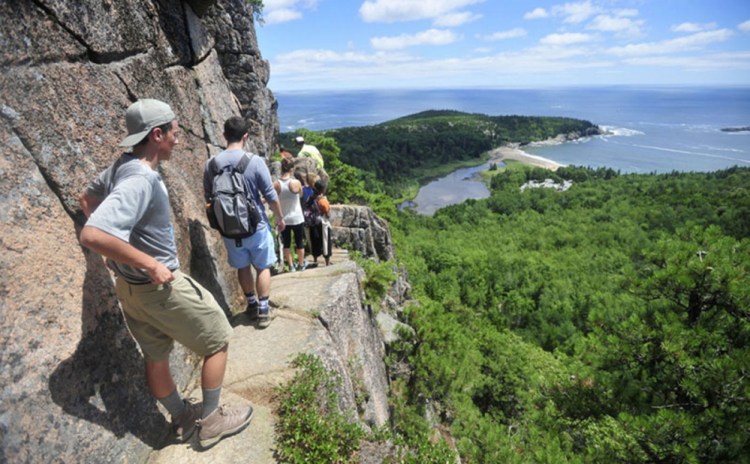 Hikers file up the Beehive Trail at Acadia National Park. 