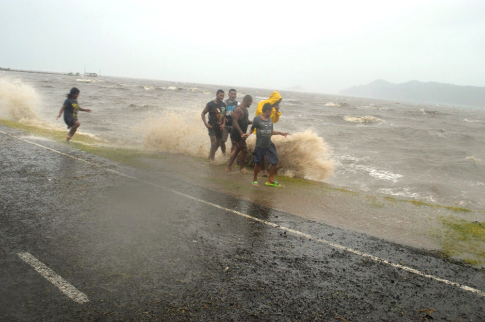 People are splashed by a wave whipped up by the approaching Cyclone Winston in Labasa, Fiji, on Saturday.