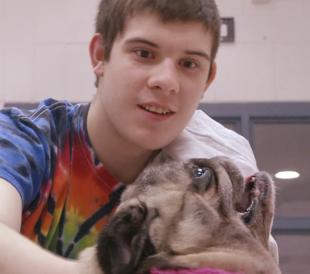 Kastan O’Dell, a resident at the Long Creek Youth Development Center in South Portland, enjoys a few moments with a pug named Cuppy as part of the facility’s pet therapy program.