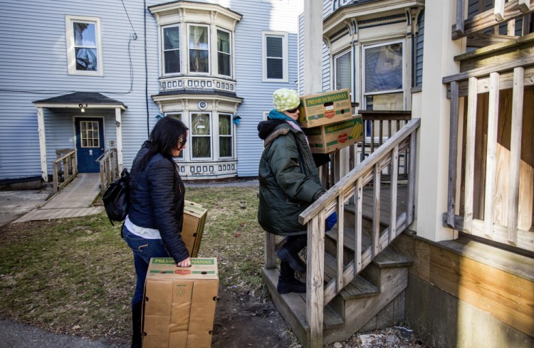 Anna Teague, right, and Chrissy Whitlock, a case manager from Shalom House, carry boxes Monday to Teague’s apartment. Teague, one of numerous residents being evicted from buildings at 61-69 Grant St., said moving has been especially hard because she has cancer.