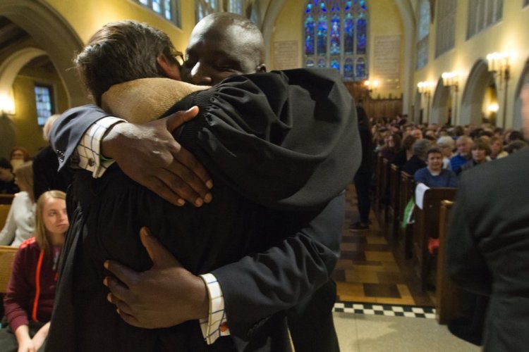 Mayor Bobby Hopewell hugs Rev. J Barrett Lee before the First Congregational Church candlelight vigil in remembrance of the mass shooting victims on Monday, in Kalamazoo, Mich.