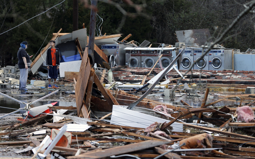Spectators walk through debris left by a deadly storm that swept through Waverly, Va., on Wednesday.