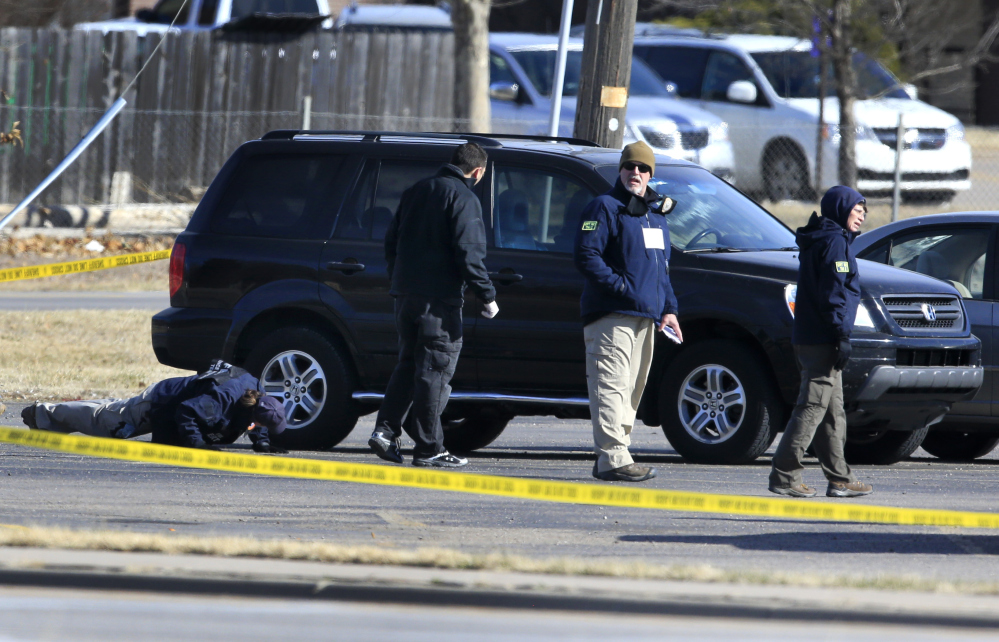 FBI agents search the parking lot at Excel Industries, the scene of Thursday’s shooting in Hesston, Kan., on Friday. Harvey County Sheriff T. Walton identified the gunman as Cedric Ford, who stormed into the factory where he worked and shot 14 people.