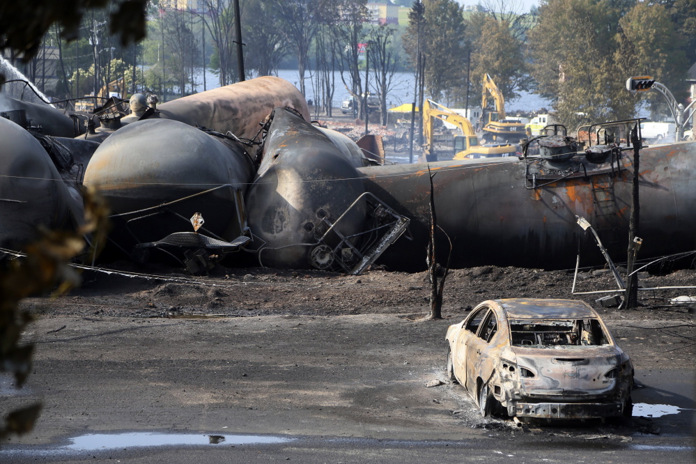 A burnt-out vehicle sits near a train derailment in Lac-Megantic, Quebec, in 2013. A report by the U.S. Department of Transportation’s inspector general is calling for greater accountability by federal regulators to prosecute rail safety violations.