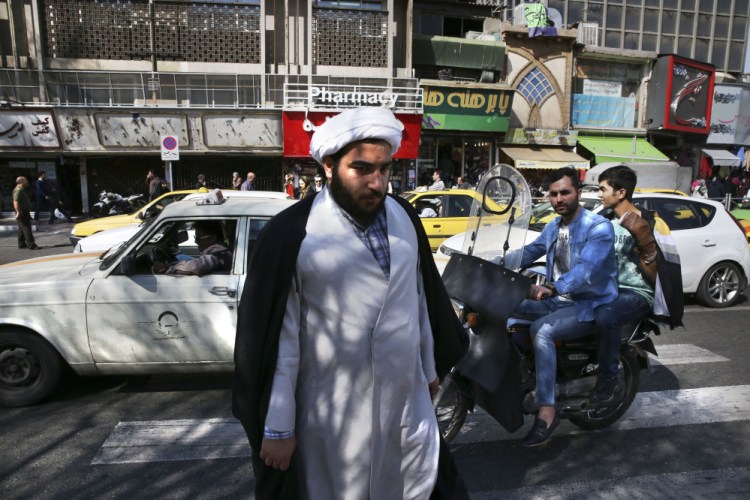 A clergyman crosses a square in central Tehran on Saturday, a day after elections in Iran.