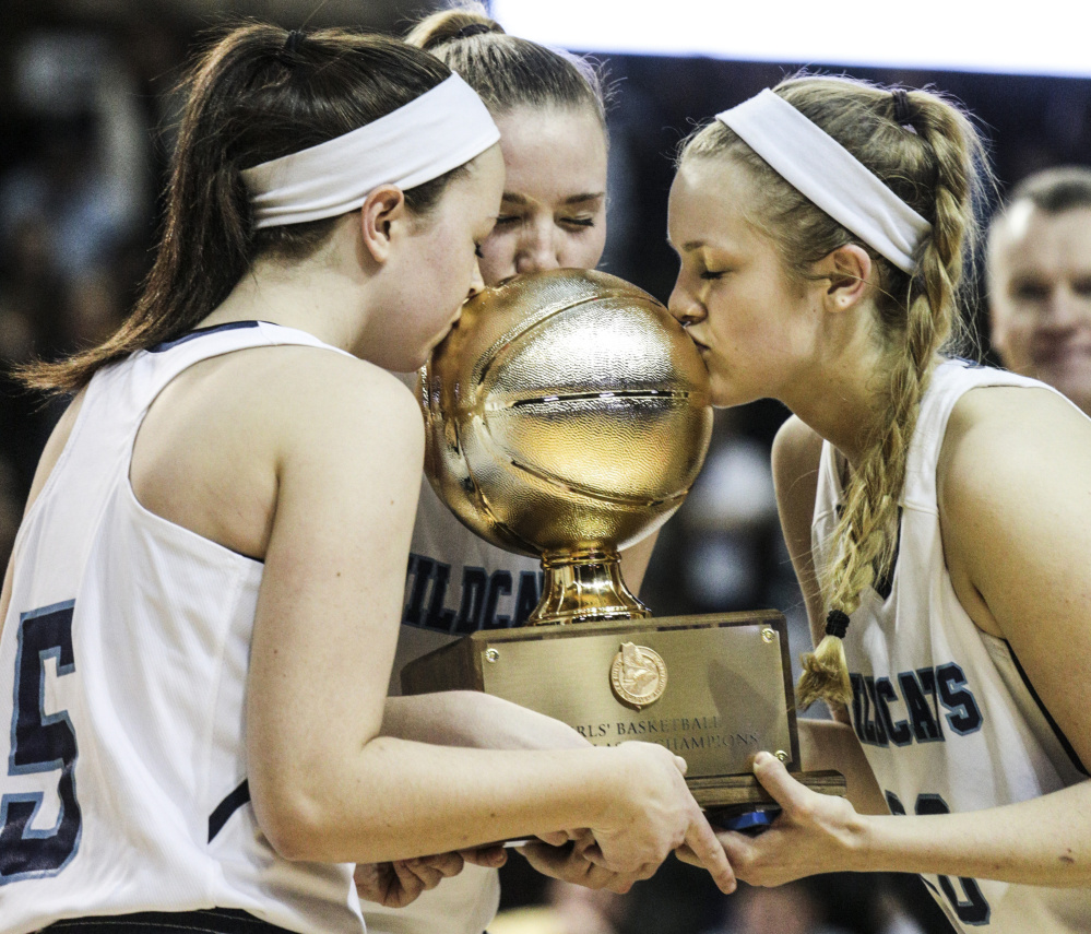 York seniors Erin McCafferty, left, Shannon Todd, center, and Chloe Smedley kiss the Class A girls’ championship ball at the Cross Insurance Arena in Portland on Saturday.