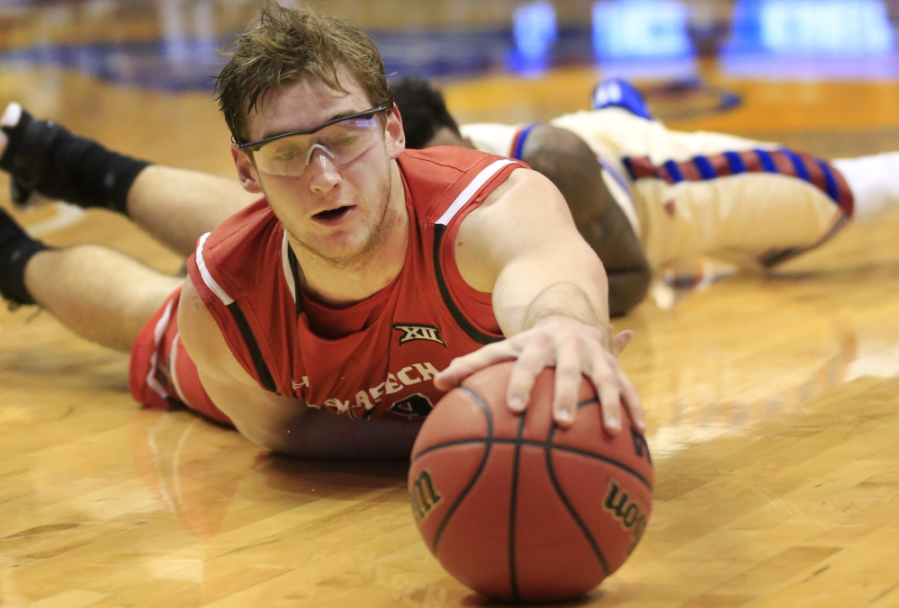 Texas Tech forward Matthew Temple reaches for a loose ball during the first half of the Red Raiders’ 67-58 loss to No. 2 Kansas on Saturday in Lawrence, Kansas.