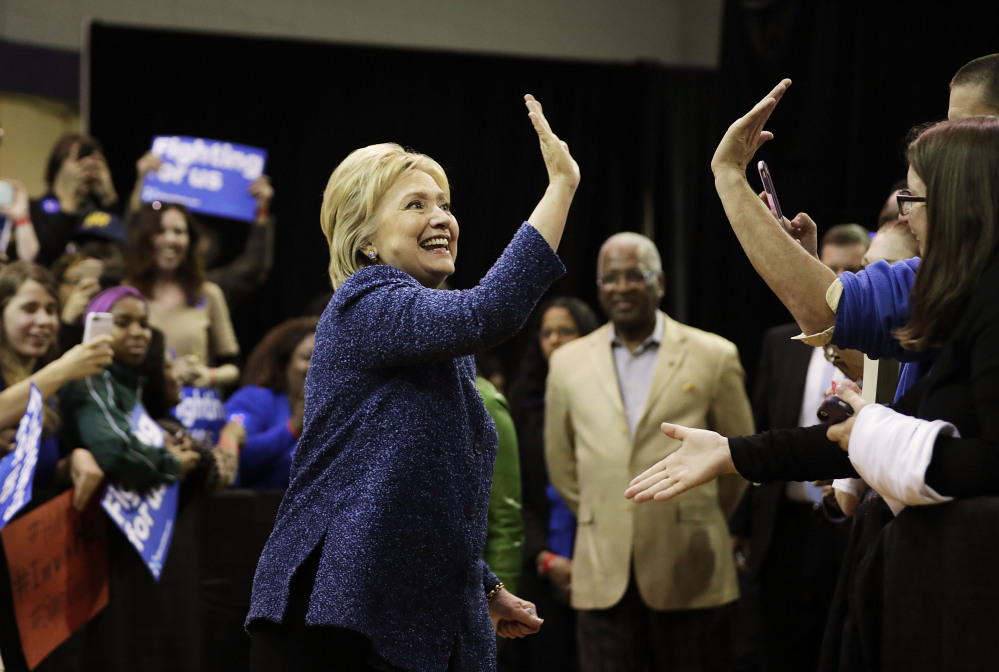 Democratic presidential candidate, Hillary Clinton high-fives an audience member as she arrives for a campaign event at Miles College Saturday, Feb. 27, 2016, in Fairfield, Ala. (AP Photo/David Goldman)