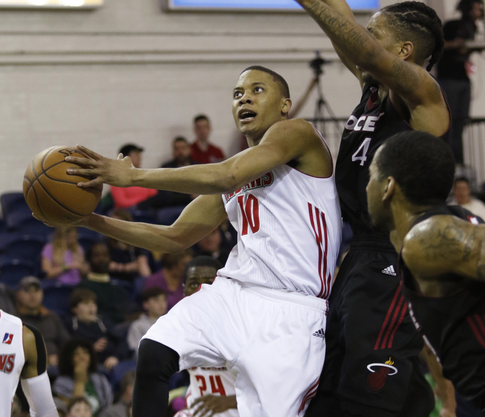 Tim Frazier goes up for a shot Sunday against Rodney McGruder of the Sioux Falls Skyforce during the Maine Red Claws’ 132-111 win at the Portland Expo. Frazier recorded a triple-double with 24 points, 12 rebounds and 12 assists.