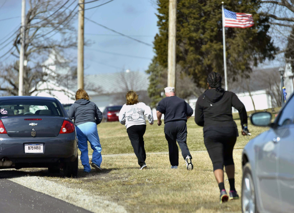 Parents run to see if they are allowed to pick up their children Monday after a school shooting at Madison Local Schools in Madison Township in Butler County, Ohio.