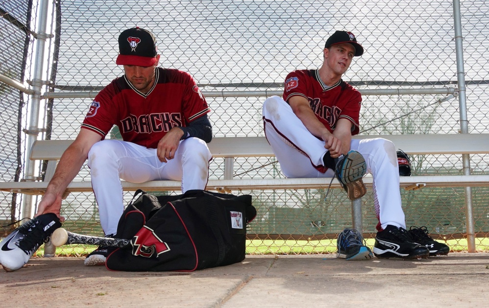 Arizona pitchers Zack Greinke, right, and Robbie Ray change out of their spikes after a workout during a spring training session Monday at Scottsdale, Arizona.