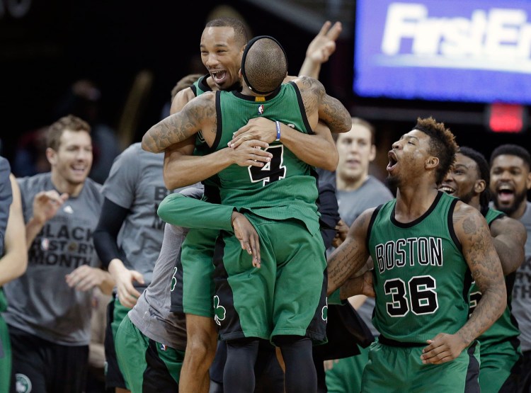 Boston Celtics' Avery Bradley, top, and Isaiah Thomas hug after the Celtics defeated the Cleveland Cavaliers 104-103 Friday in Cleveland. Bradley made a corner jumper at the horn to give the Celtics the win.