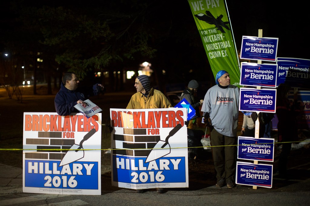 Backers of Hillary Clinton and Bernie Sanders show competing signs before the debate.