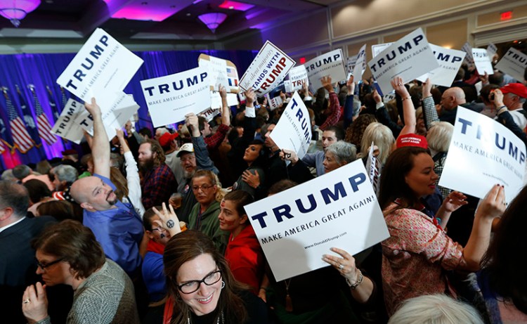 Supporters for Republican presidential candidate Donald Trump hold signs during a South Carolina Republican primary night event. in Spartanburg, S.C. 