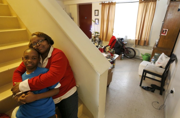 Debra Aldridge, right, poses for a portrait with her grandson, Mario Hendricks, at her home on Chicago's South Side. 
The Associated Press