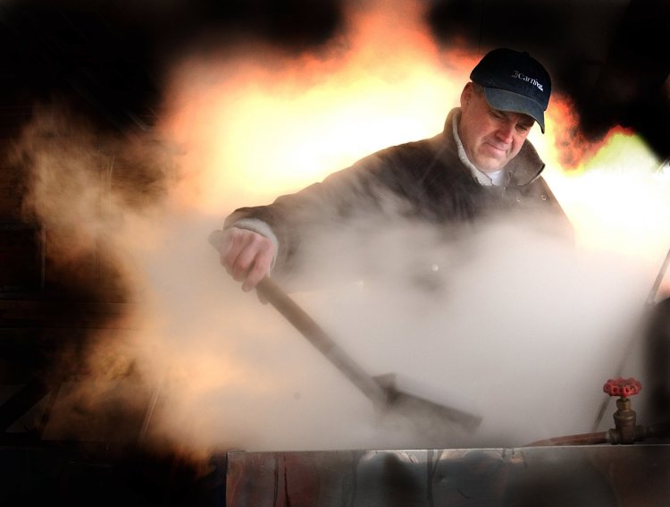 George Phelps of Gardiner skims the tanks of his home made sap boiler as he creates maple syrup in his garage. Some maple syrup producers have asked the FDA to crack down on businesses claiming their products contain maple syrup when they do not.

Photo by Fred J. Field