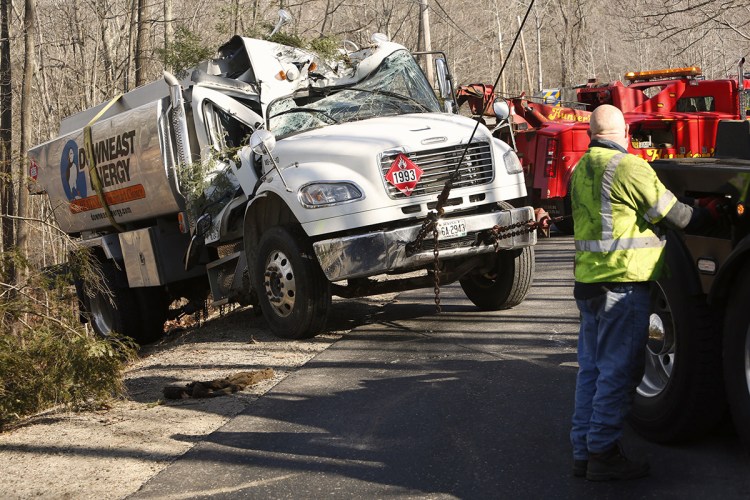 An oil truck that tipped off the edge of Hunter Road in Freeport is pulled back onto the road by a wrecker crew Monday morning. 