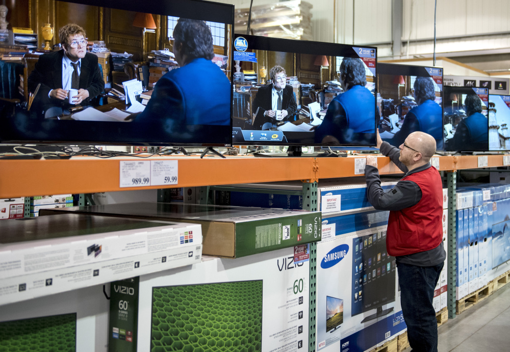 An employee adjusts a TV set at a store in Ottawa, Ontario, on Tuesday as Canada begins phasing in a choose-your-channels system. The change may answer the question of who will win and lose if every channel goes it alone.