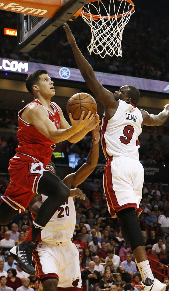 Doug McDermott of the Chicago Bulls attempts to lay the ball up over Luol Deng of the Miami Heat during the first half of Miami’s 129-111 win Tuesday.