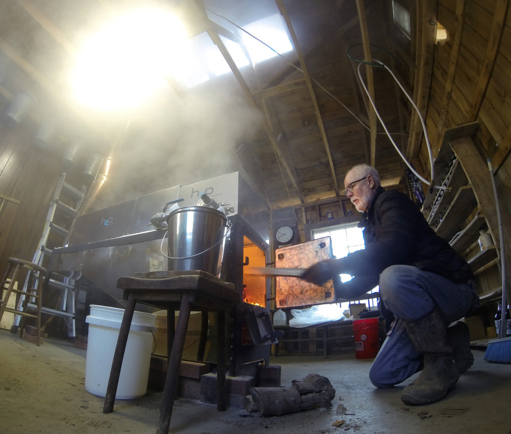 Mike Meagher, who operates Maine-iac Maple Farm in Richmond, throws more wood into the fire box under the evaporator Tuesday. He was tapping the 200 maple trees on his 15-acre property earlier than usual this year, after a dismal 2015.