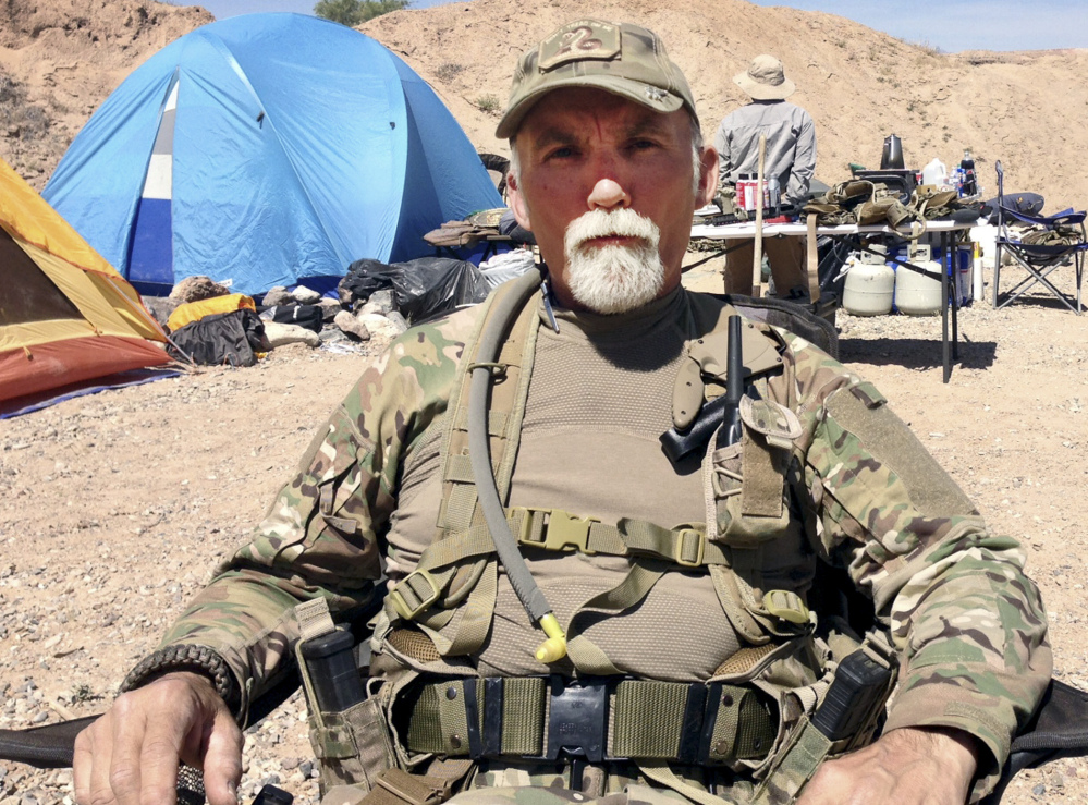 Gerald “Jerry” DeLemus of Rochester, N.H., sits among a group of militia members camping on Cliven Bundy’s ranch near Bunkerville, Nev., in 2014.