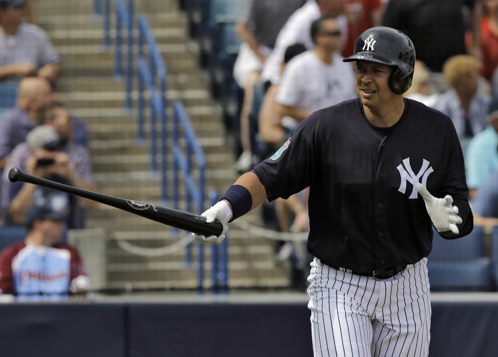 Alex Rodriguez of the Yankees hands his bat to a batboy Thursday after hitting a two-run home run off Philadelphia pitcher Adam Morgan in the first inning of a 13-4 spring training win for New York at Tampa, Florida. The homer came in Rodriguez’s first at-bat of the spring.