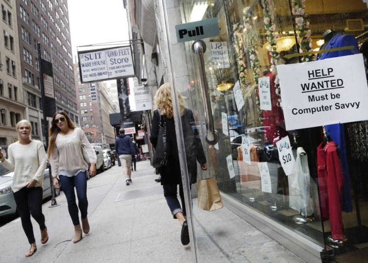 A “Help Wanted” sign hangs in a store window in New York in October. U.S. employers added 242,000 workers in February as retailers, restaurants and health care providers drove another solid month for the American job market. The Labor Department said the unemployment rate held steady at 4.9 percent.