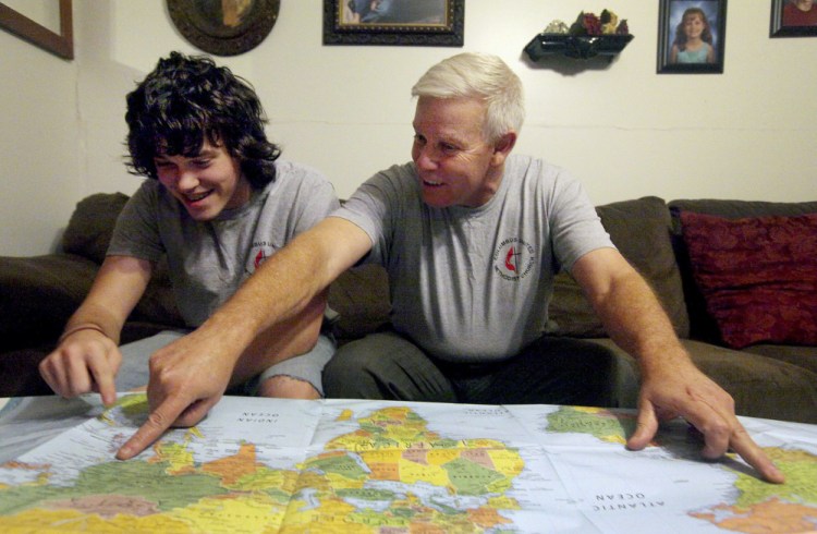 Steve Keppner of Coatsburg, Ill., points out the distance he and his son, Jake, will travel on their upcoming trip to the Philippines. “I couldn’t let him go alone,” Steve said. The Associated Press