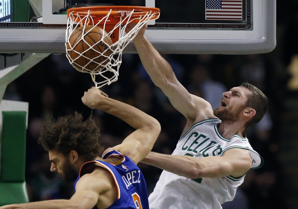 The Celtics’ Tyler Zeller dunks over the Knicks’ Robin Lopez in the dramatic fourth quarter of Friday night’s game in Boston.