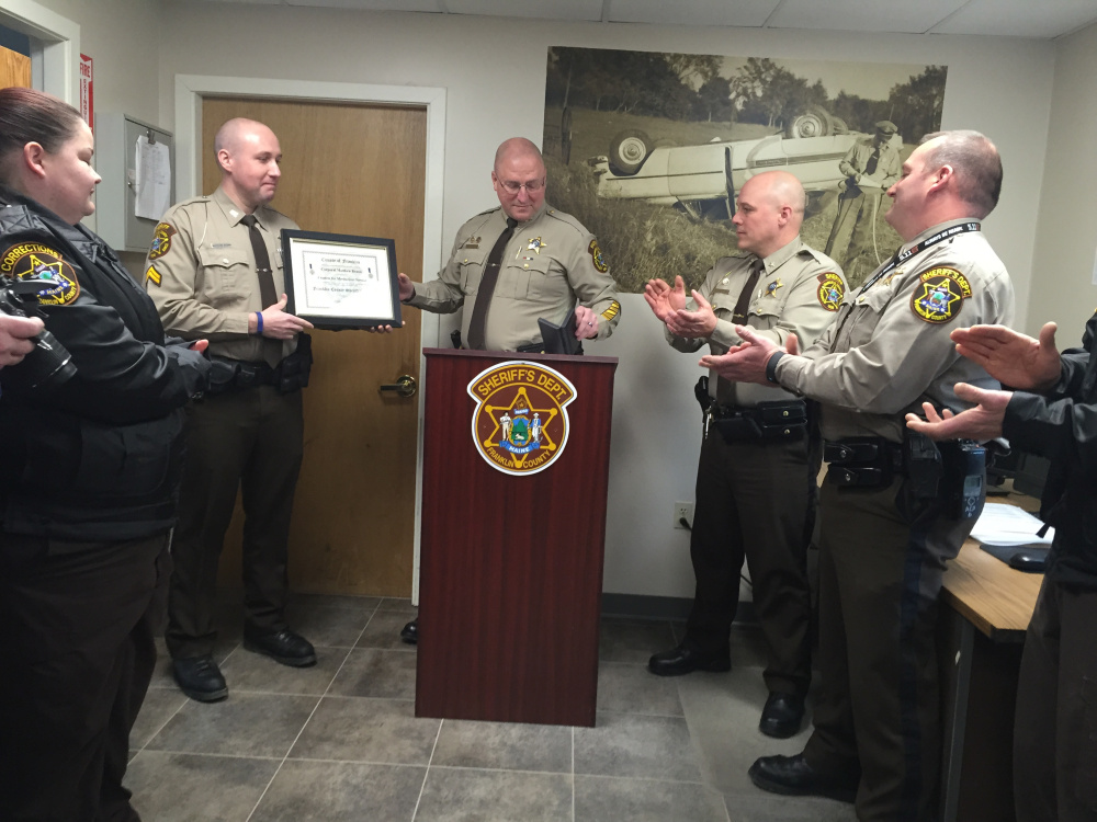 Cpl. Matthew Brann receives the Meritorious Service Award for his part in helping save the life of a truck driver who was shocked by electrical wires in December while delivering grain in New Vineyard.